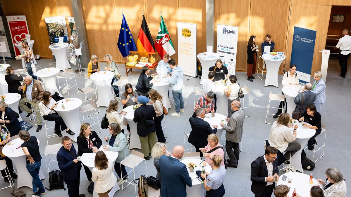 Empfang nach dem Auftakt-Programm © Jörg Farys / BBE Vogelspektive auf ein Foyer mit Stehtischen und Stühlen, an denen sich Menschen befinden, miteinander sprechen, essen und trinken.
