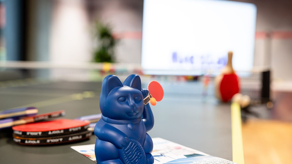 Tischtennis beim Thementag © Jörg Farys Eine blaue Winkekatze mit einer Tischtenniskelle steht auf einer Tischtennisplatte.
