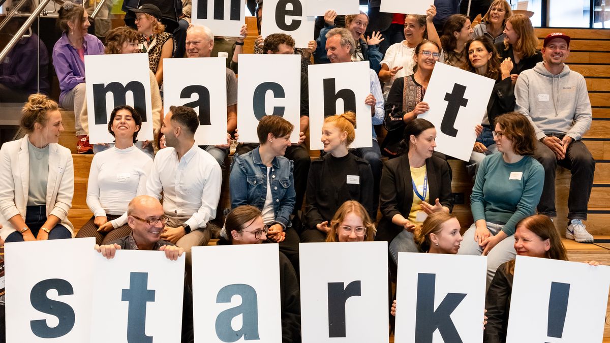 Gruppenfoto © Jörg Farys Gruppenfoto auf einer Treppe. Einige halten Buchstaben hoch, die den Satz "Engagement macht stark!" ergeben.