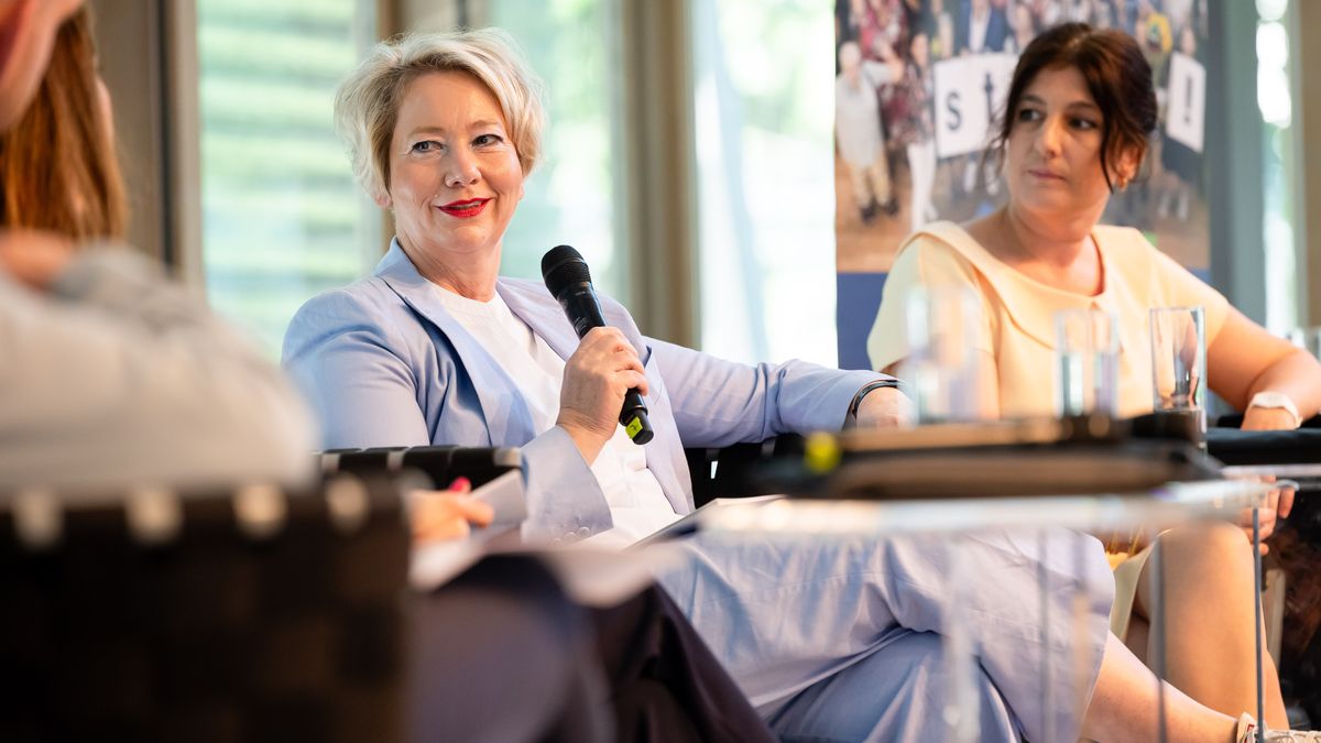 Podiumsdiskussion zum Thema Einsamkeit © Jörg Farys / BBE Zwei Frauen sitzen nebeneinander auf einer Bühne. Eine Frau hält ein Mikrofon.
