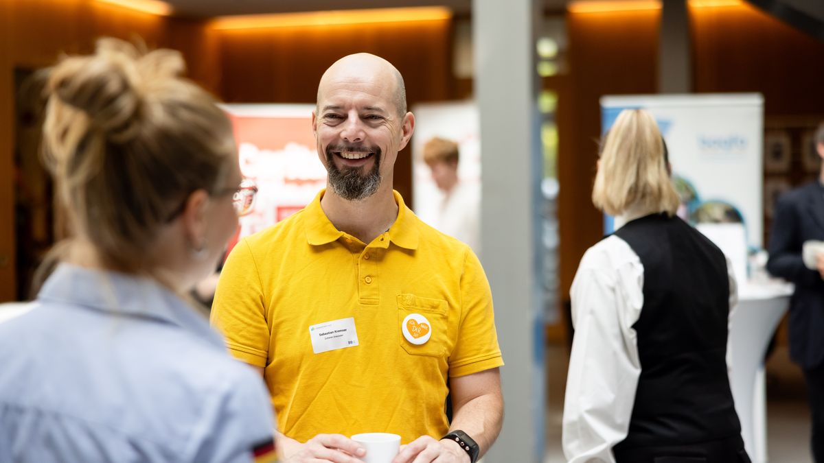 Markt der Gemeinsamkeiten © Jörg Farys / BBE Ein Mann unterhält sich mit einer Frau an einem Stehtisch.