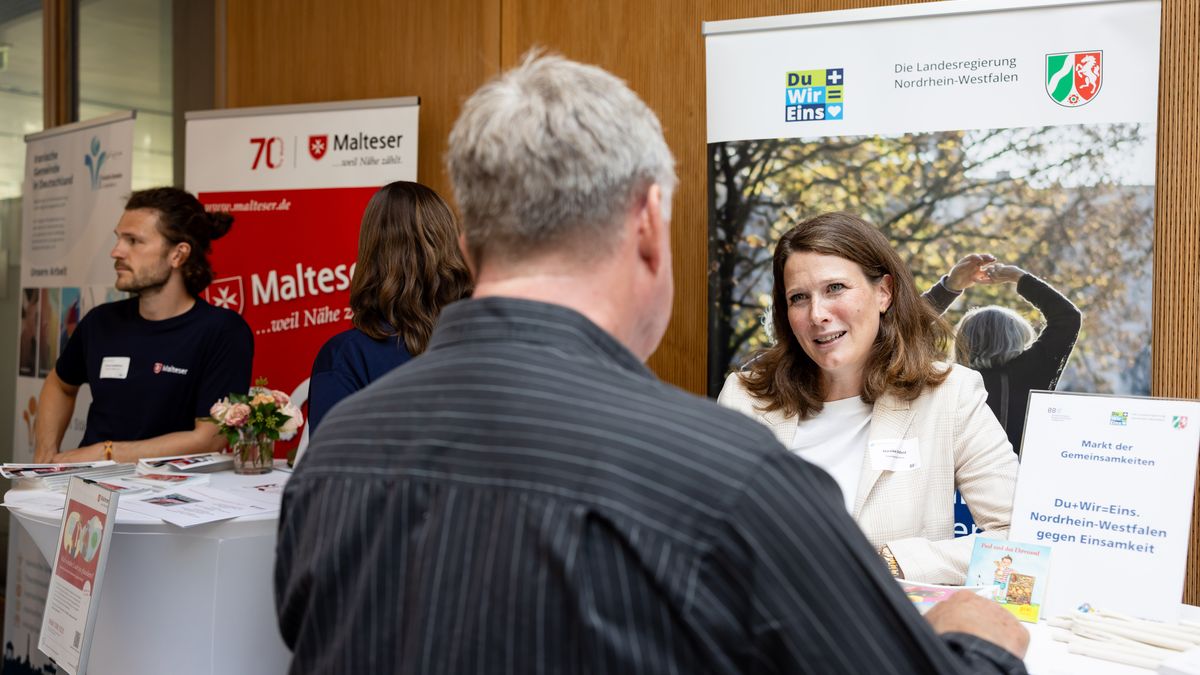 Markt der Gemeinsamkeiten © Jörg Farys / BBE Menschen unterhalten sich an Infoständen von Malteser und dem NRW-Projekt "Du+Wir=Eins"