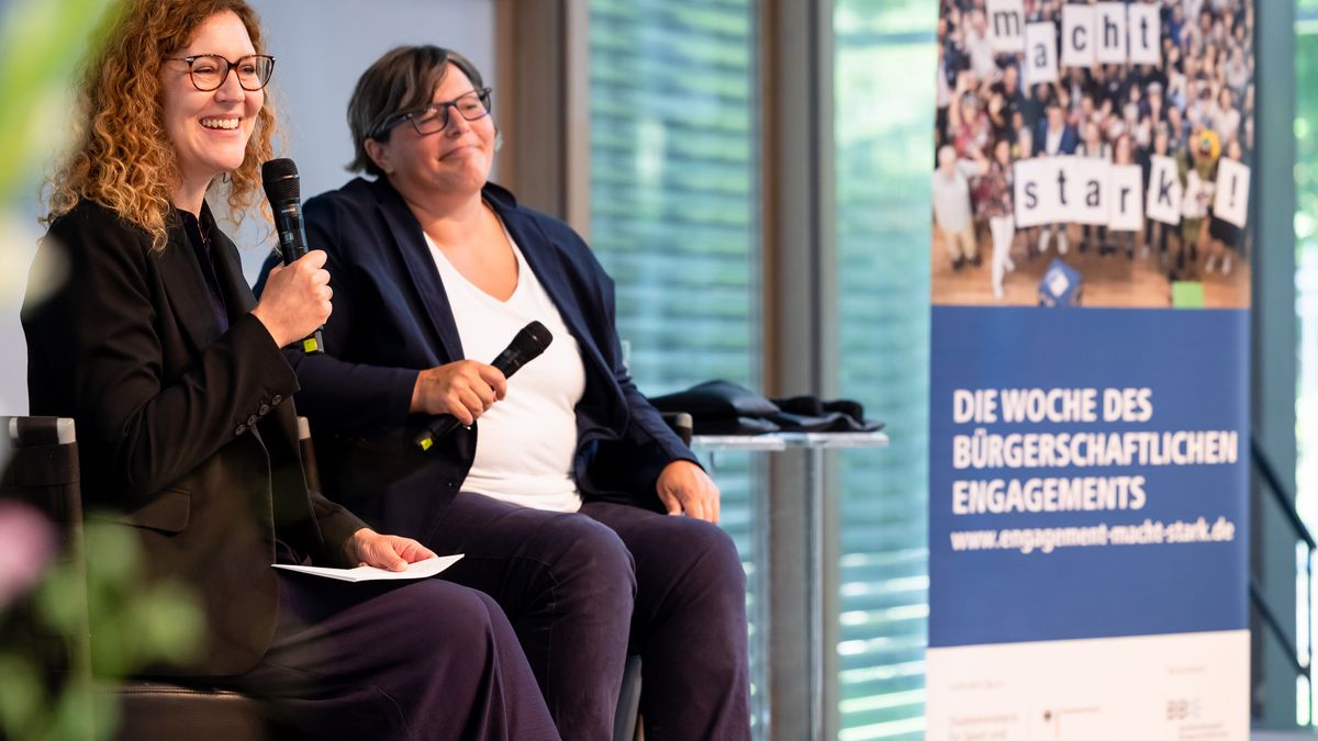 Fachgespräch: Engagiert für die Zukunft © Jörg Farys / BBE Zwei Frauen sitzen nebeneinander in der Bühne mit jeweils einem Mikro in der Hand und schauen nach vorn. Daneben steht ein Rollup von der Woche des bürgerschaftlichen Engagements.