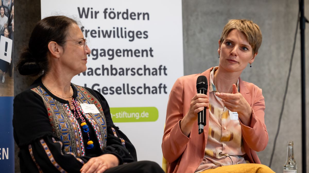 Gespräche im Panel © Jörg Farys Zwei Frauen sitzen nebeneinander. Eine Frau hält ein Mikrofon und spricht.