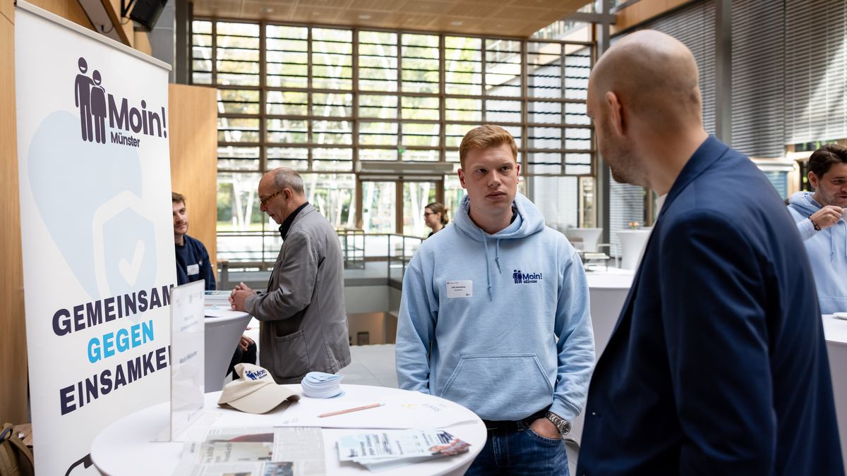 Moin! Münster beim Markt der Gemeinsamkeiten © Jörg Farys / BBE Zwei Männer unterhalten sich an einem Infostand von Moin Münster!